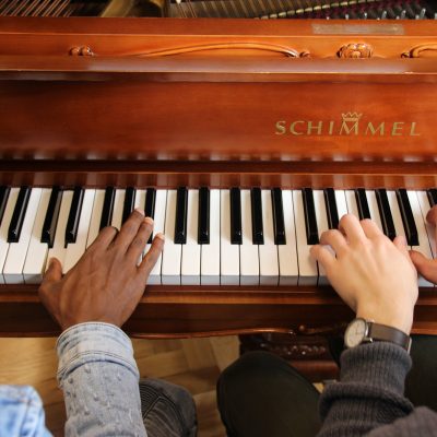 Vier Hände am Klavier